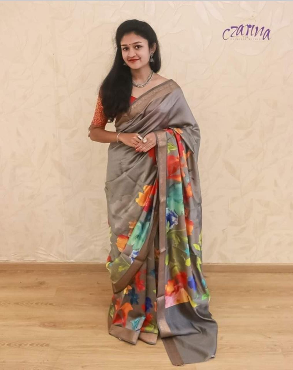 MULTICOLOURED FLORAL PATTERN ADORNS THE SILVER GREY BENARSI CHINIYA SILK SAREE.